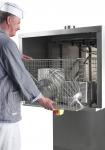 Opérateur en tenue de boulanger ouvrant la grille de protection du tunnel de lavage JEROS 300 pour accéder aux ustensiles